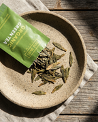 Organic Long Jing green loose leaf tea in a ceramic bowl — Wu Wei Living