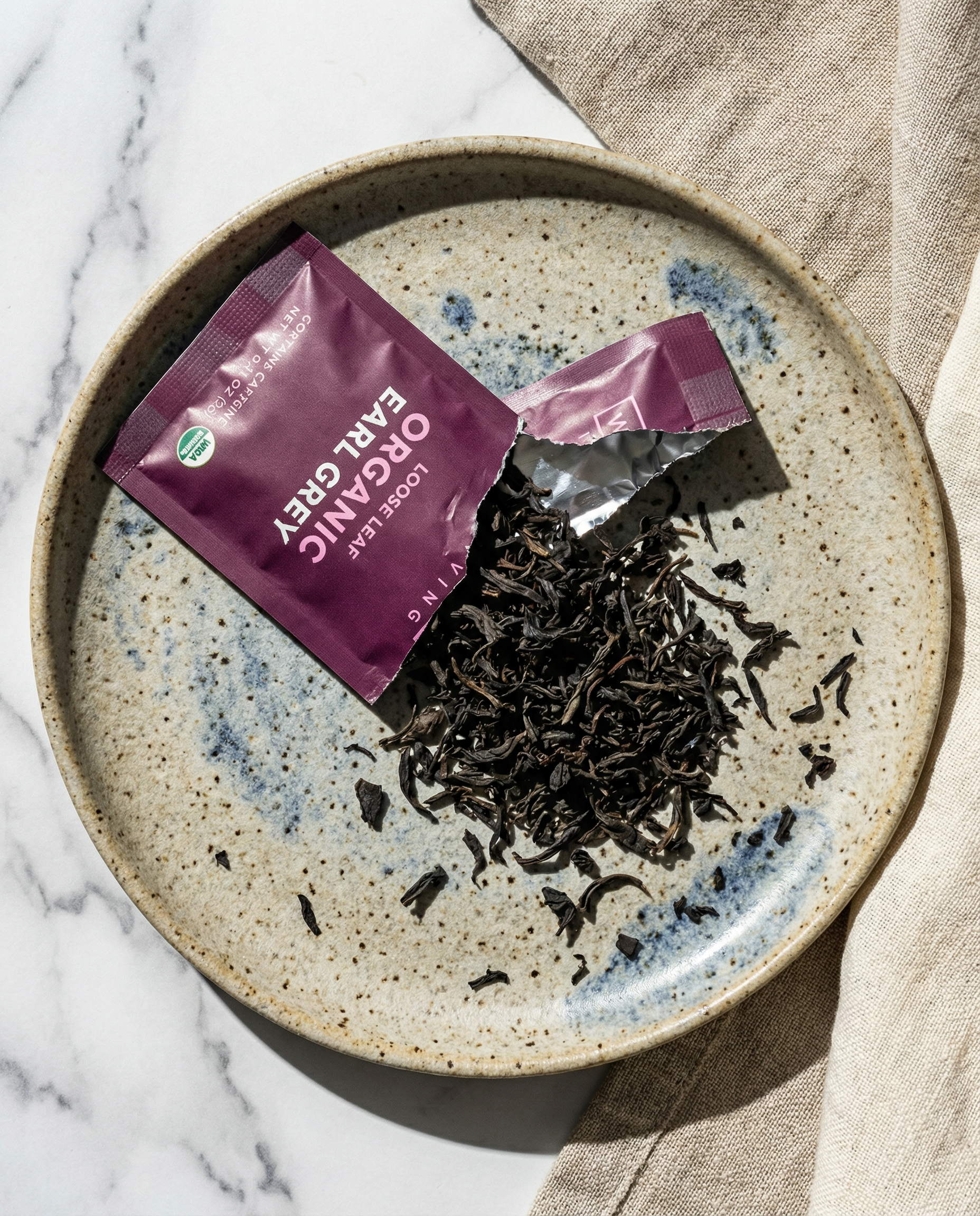Tea leaves on a speckled ceramic plate - Wu Wei Living Organic Earl Grey
