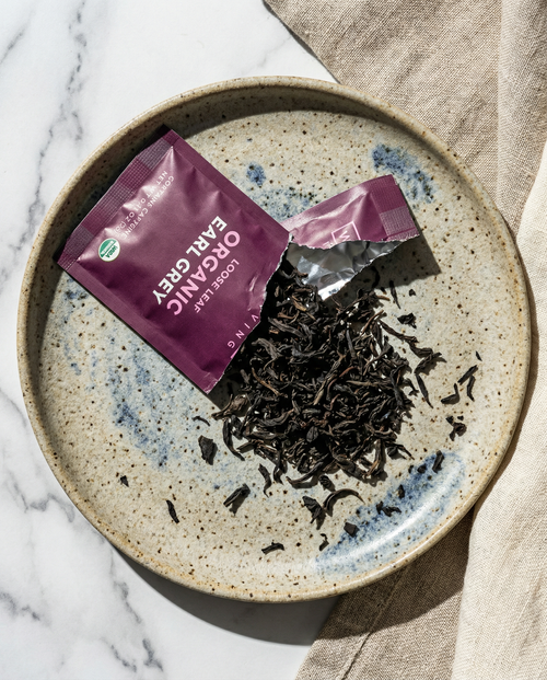 Tea leaves on a speckled ceramic plate - Wu Wei Living Organic Earl Grey